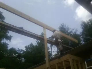 Carpenter setting a ridge beam over a new addition frame — Ice Dam Removal by Roofing Brothers in Herkimer