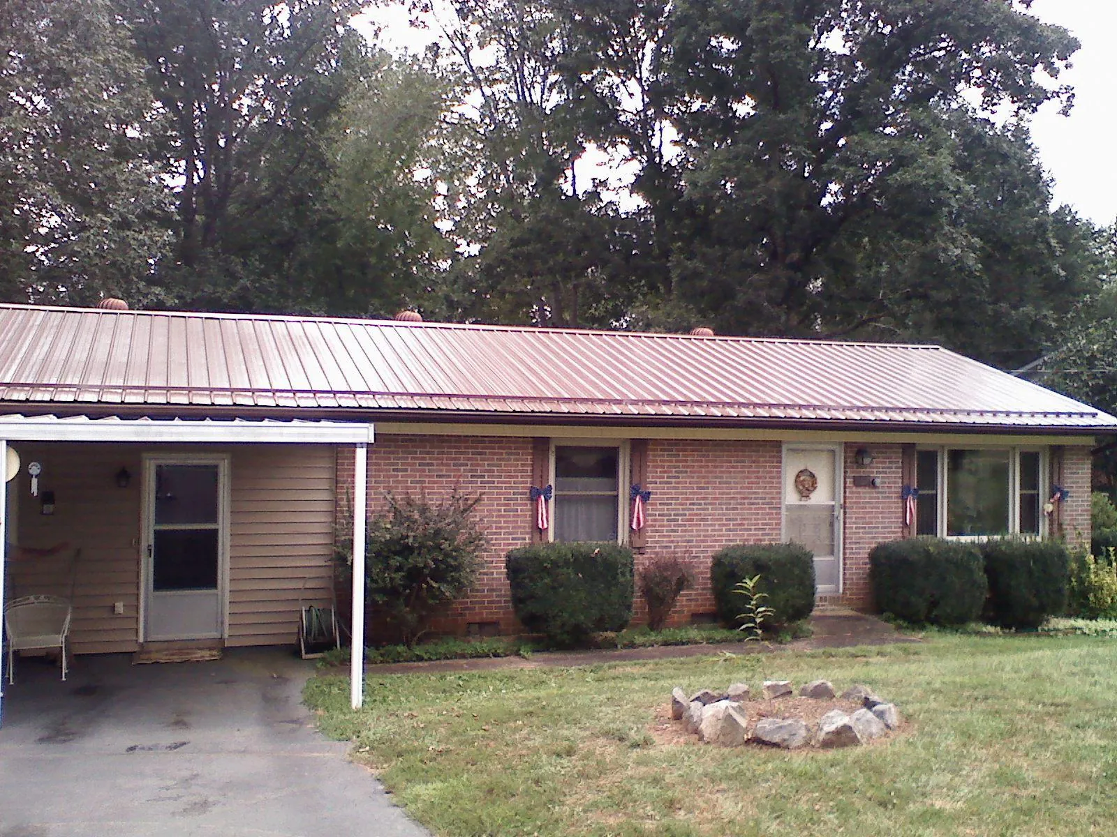Bronze metal roof and carport on a brick ranch home — Roof Repair work by our crew in Herkimer