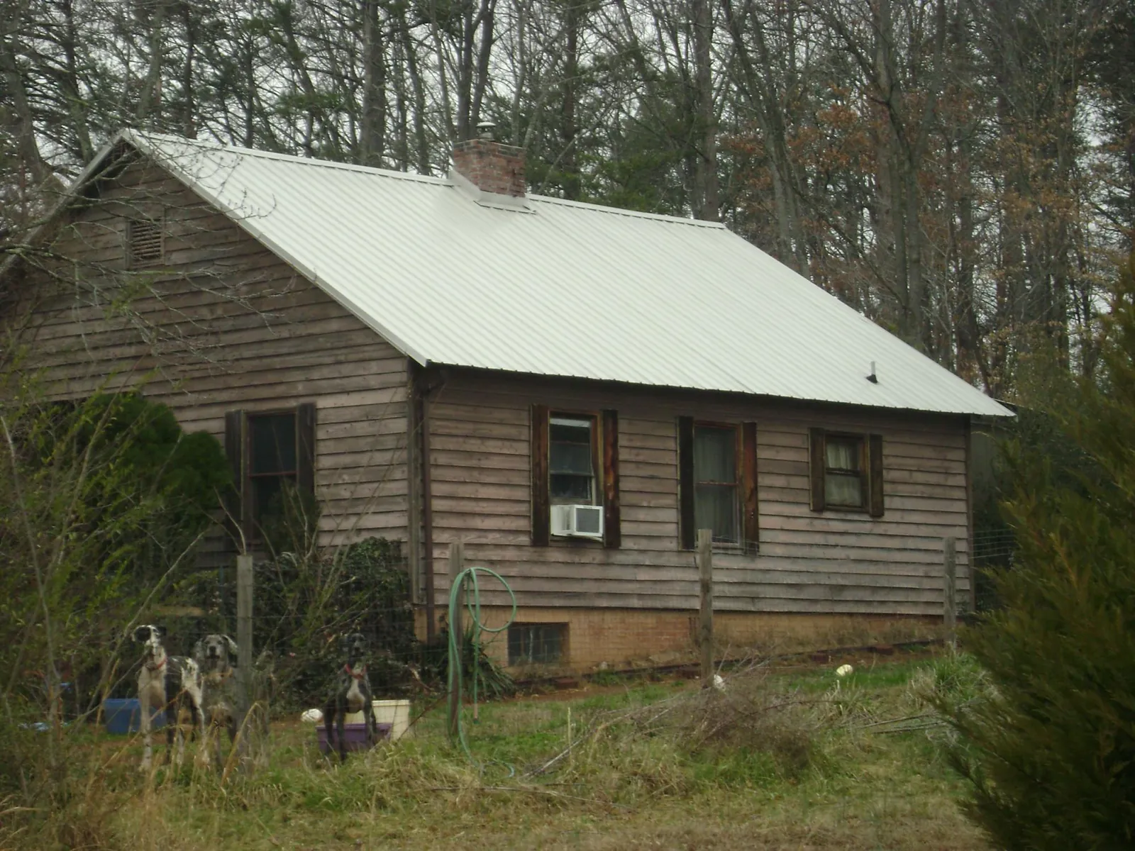 White metal roof on an old wood sided farmhouse, from a Metal Roof Installation job in Herkimer